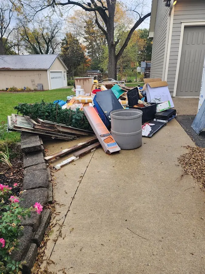 Dumpster being loaded with debris for Estate Cleanout Dumpster Rental in Lakes of the Four Seasons